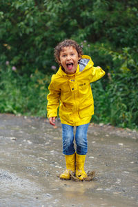 Portrait of smiling boy standing on dirt road