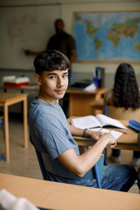 Portrait of teenage boy in high school classroom