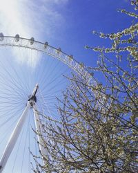 Low angle view of ferris wheel against clear blue sky