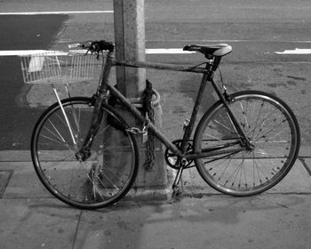 Bicycle parked on footpath against wall