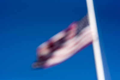 Close-up of hand against blue sky