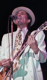 Mid adult man playing guitar at music concert