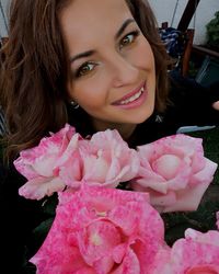 Portrait of smiling woman with pink flower