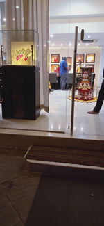 Rear view of man standing on table at store