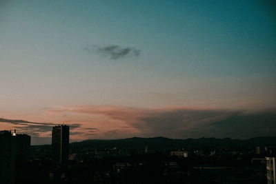 Silhouette buildings against sky at sunset