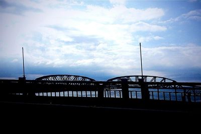 Bridge against cloudy sky