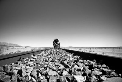 Man standing on railroad track against sky
