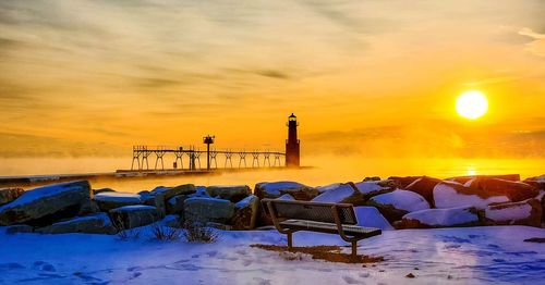 Scenic view of frozen lake against orange sky during sunset