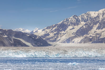 Scenic view of snowcapped mountains by sea against sky