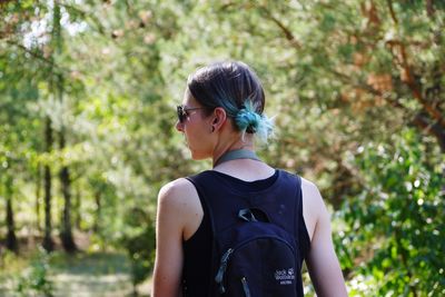 Rear view of woman standing against trees
