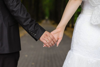 A man holds a woman's hand. hands of the bride and groom with a wedding ring close-up