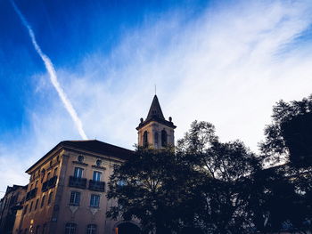 Low angle view of trees and building against sky