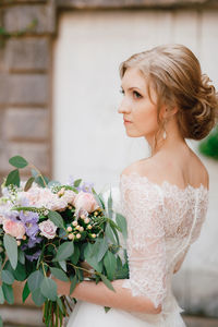 Close-up of woman looking away holding bouquet