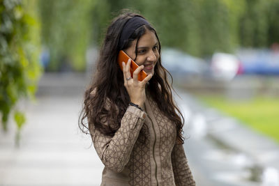 Attractive teenager girl having a phone conversation in a space
