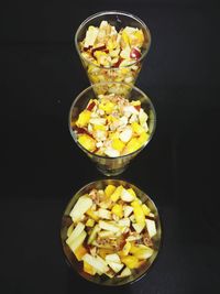 Close-up of chopped fruits on table against black background