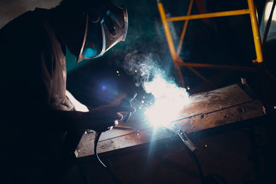 Man welding metal in workshop