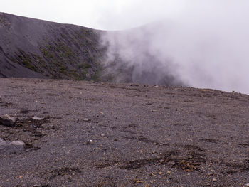 Smoke emitting from volcanic mountain against sky