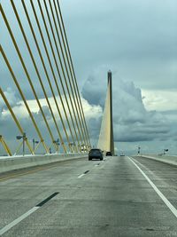 Cars on bridge against sky