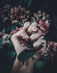 Cropped image of man clutching flowers at park