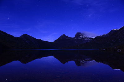 Reflection of mountains in lake at night