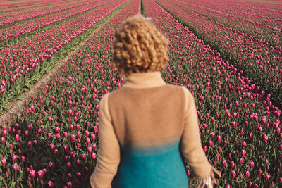 Rear view of woman standing on a tulip field