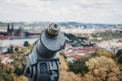 Close-up of coin-operated binoculars against cityscape