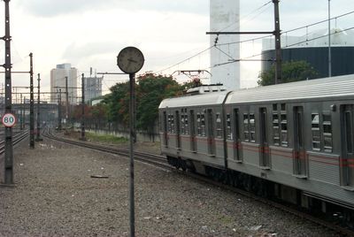 Train at railroad station in city against sky
