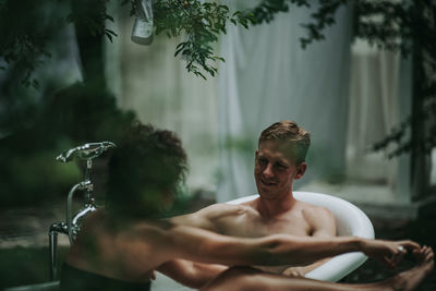 Portrait of shirtless young man in water