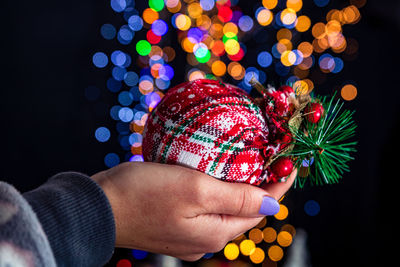 Midsection of woman holding illuminated christmas lights