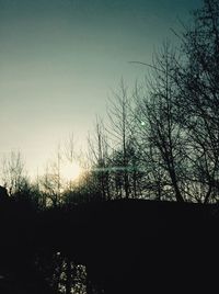 Silhouette bare trees against sky at sunset