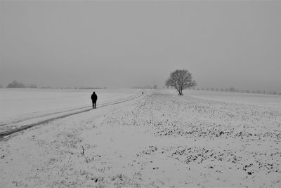 Scenic view of snow covered field against sky