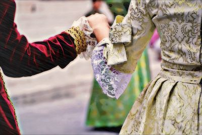 Cropped image of man and woman in corteo storico holding hands