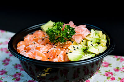 Close-up of chirashi in bowl on table against black background