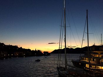 Sailboats in sea at sunset