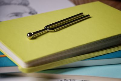 Close-up of tuning fork on notebook