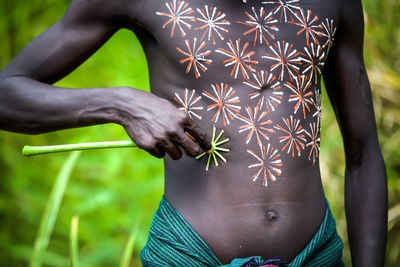 Midsection of man with woman standing against plants