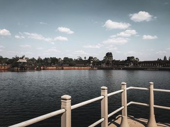 Scenic view of river by buildings against sky