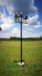 Street light on field against sky