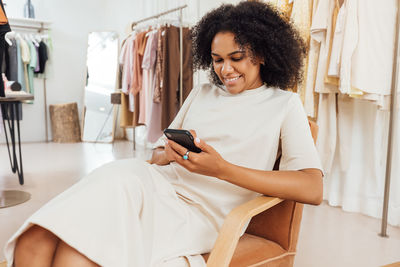 Young woman using mobile phone while sitting at home