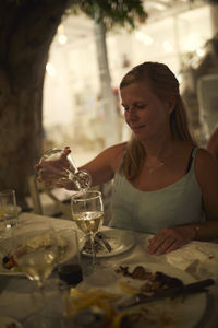 Woman pouring white wine into glass