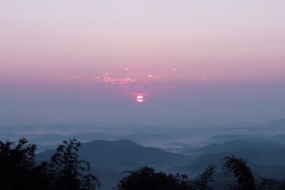 Scenic view of silhouette mountains against sky at sunset