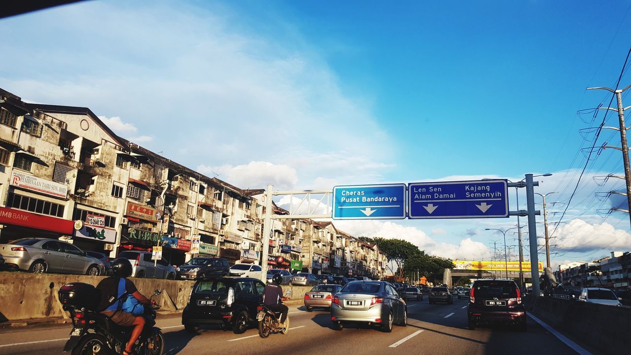 VEHICLES ON ROAD AGAINST BUILDINGS