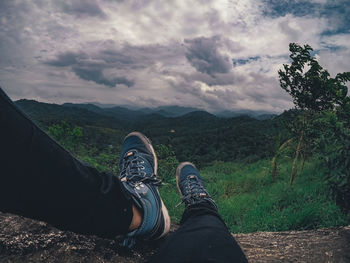 Low section of person wearing shoes on land