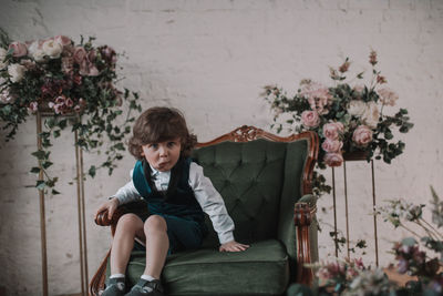 Portrait of boy sitting on flower plant