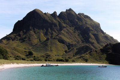 Scenic view of sea and mountains against sky