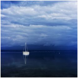 Yacht on sea against cloudy sky