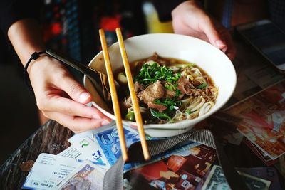 Midsection of person holding food on table