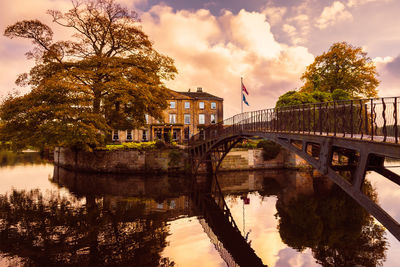 Bridge over river against sky during sunset