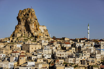 Buildings in city against clear blue sky