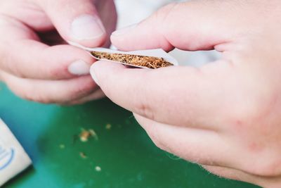 Close-up of human hands holding tobacco product